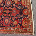 An Antique Malayan handmade red and blue ground floral pattern rug, 6'11" x 4'10"