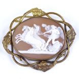 A large relief carved cameo brooch, depicting Classical winged figure with 3 horses, in unmarked