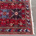 A Caucasian handmade red and blue ground geometric pattern rug, 6'9" x 4'9"