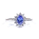 A 9ct white gold tanzanite and diamond cluster ring, total diamond content approx 0.25ct, setting