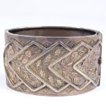 A Victorian wide silver hinged bangle, with applied 2-tone gold floral decoration, by Michael Joseph