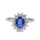 An 18ct white gold sapphire and diamond cluster ring, oval-cut sapphire approx 1.1ct, setting height