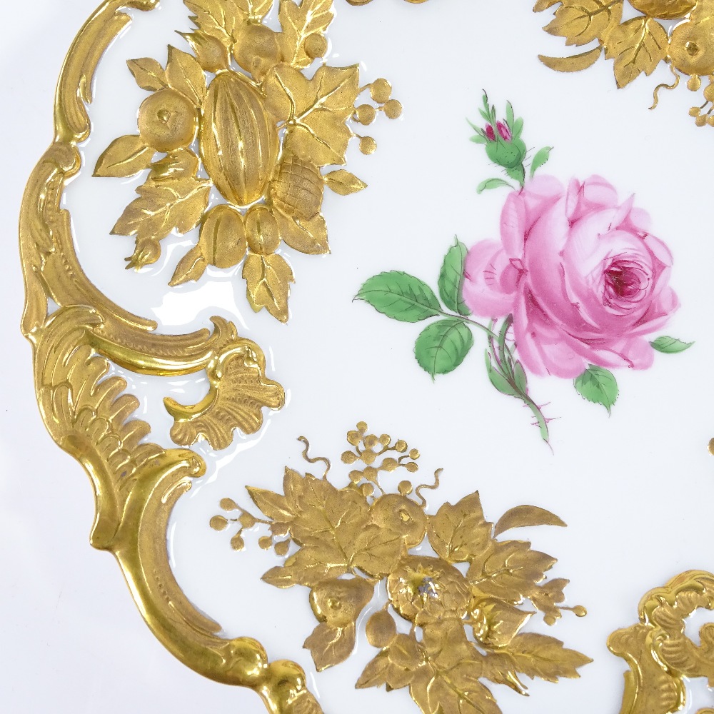 A Meissen porcelain plate with relief moulded and gilded border, and hand painted rose, diameter