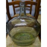 A green glass carboy, and 2 other green glass bottles