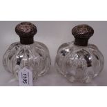 A pair of heavy cut-glass scent bottles, with embossed silver tops