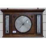 An oak aneroid barometer with thermometer