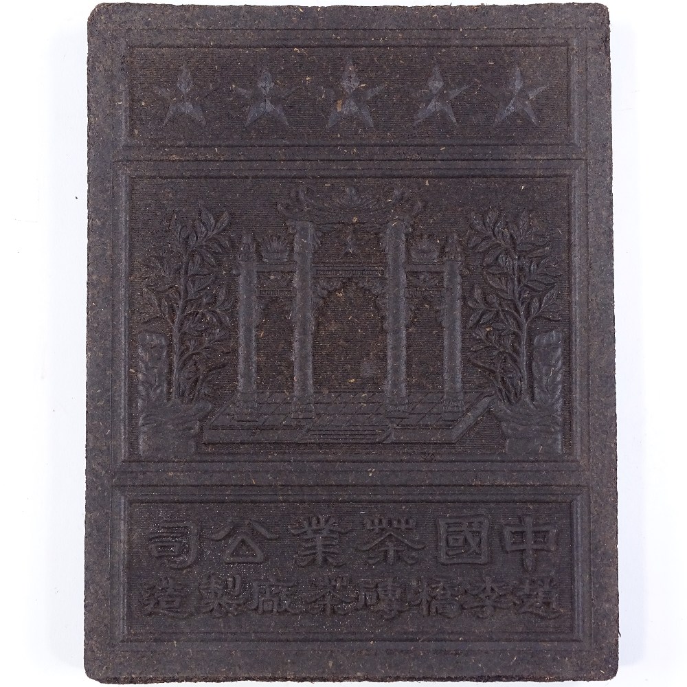 A Chinese pressed tea plaque, with relief design and text, length 24cm