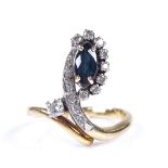 An unmarked gold sapphire and diamond crossover dress ring, set with marquise-cut sapphire,