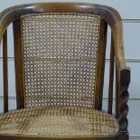 An early 20th century stained beech cane-panelled bow armchair