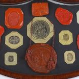 A 19th century banded mahogany shield-shaped frame containing wax seals, width 41cm