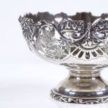 A small circular silver bon bon basket, with pierced grapevine decoration, on raised foot, by George