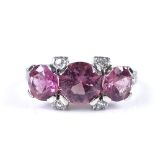 An unmarked white gold pink tourmaline and diamond trilogy ring, with diamond set shoulders,