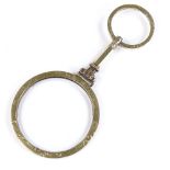 A Victorian rolled gold magnifying glass, with finger loop and engraved rim, length 75.2mm