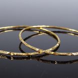 A pair of unmarked high carat gold bangles, with geometric designs, internal diameters 64mm, 17.5g