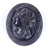 A large Whitby jet relief carved cameo brooch, depicting female portrait with Greek key surround,