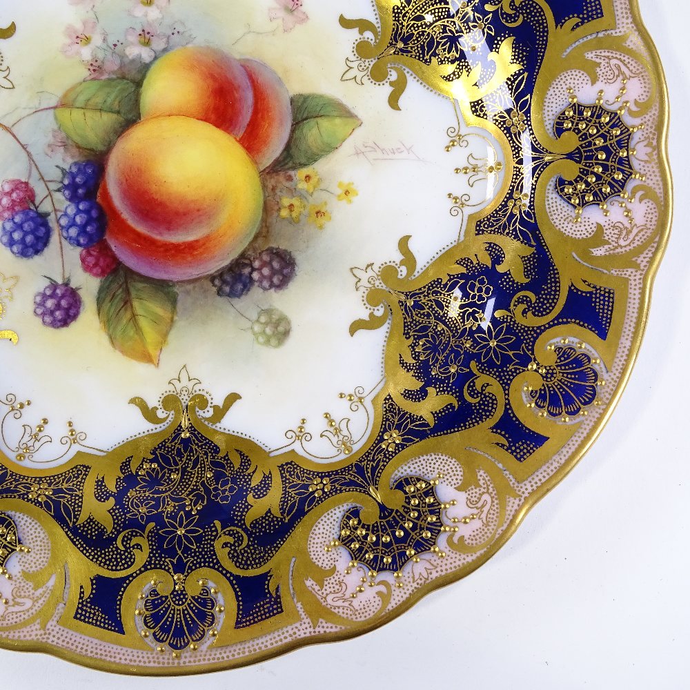A Royal Worcester porcelain cabinet plate, with hand painted fruit design in textured gilded border,