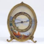 An early 20th century miniature gilt-metal cased travelling Strut clock, with painted landscape