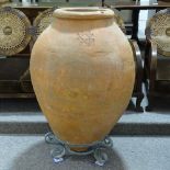 A large Islamic terracotta olive jar on wrought-iron stand, overall height 120cm
