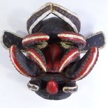A carved and painted wood African Tribal mask with metal studded decoration, height 34cm, and
