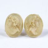 A pair of relief carved ivory cameo earrings, depicting female portraits, with silver fittings,