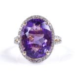 A 14ct gold amethyst and diamond halo cluster ring, with diamond set shoulders, oval-cut amethyst