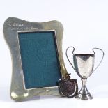 An Edwardian silver-fronted wavy photo frame, internal dimensions 13cm x 9cm, together with a