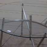 A Philippe Starck Dole Melipone dining table, by XO, with circular glass top and folding nickel