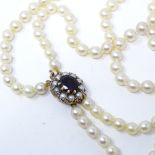A double row graduated cultured pearl choker necklace, with 9ct gold garnet and split pearl clasp,