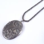 A large sterling silver oval photo locket, on long sterling silver birdcage link chain, pendant