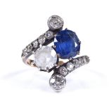 A large unmarked gold sapphire and diamond crossover ring, with graduated diamond set shoulders