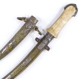 A Middle Eastern bone-handled dagger, with ornate engraved brass and white metal scabbard, and