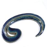 An Islamic turquoise glazed ceramic Waw script, length 28cm