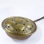 An Antique embossed brass bed-warming pan, circa 1700, with turned wood handle