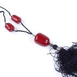 A long cherry amber bead pendant necklace, on silk thread, pendant height 37.4mm, 63.6g total