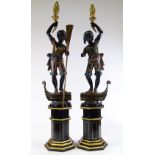 A pair of Italian carved and painted wood gondolier torchere figures, on gilded octagonal pedestals,