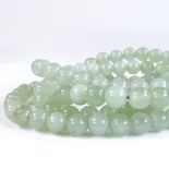 A long strand of polished jade beads, length 54cm