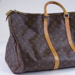 A Louis Vuitton Monogram holdall bag with tan leather straps and handles, serial number FL0020,