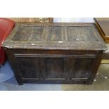 An 18th century oak coffer, with carved panel front on stile legs