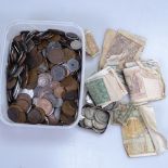 A boxful of various coins and banknotes, including silver