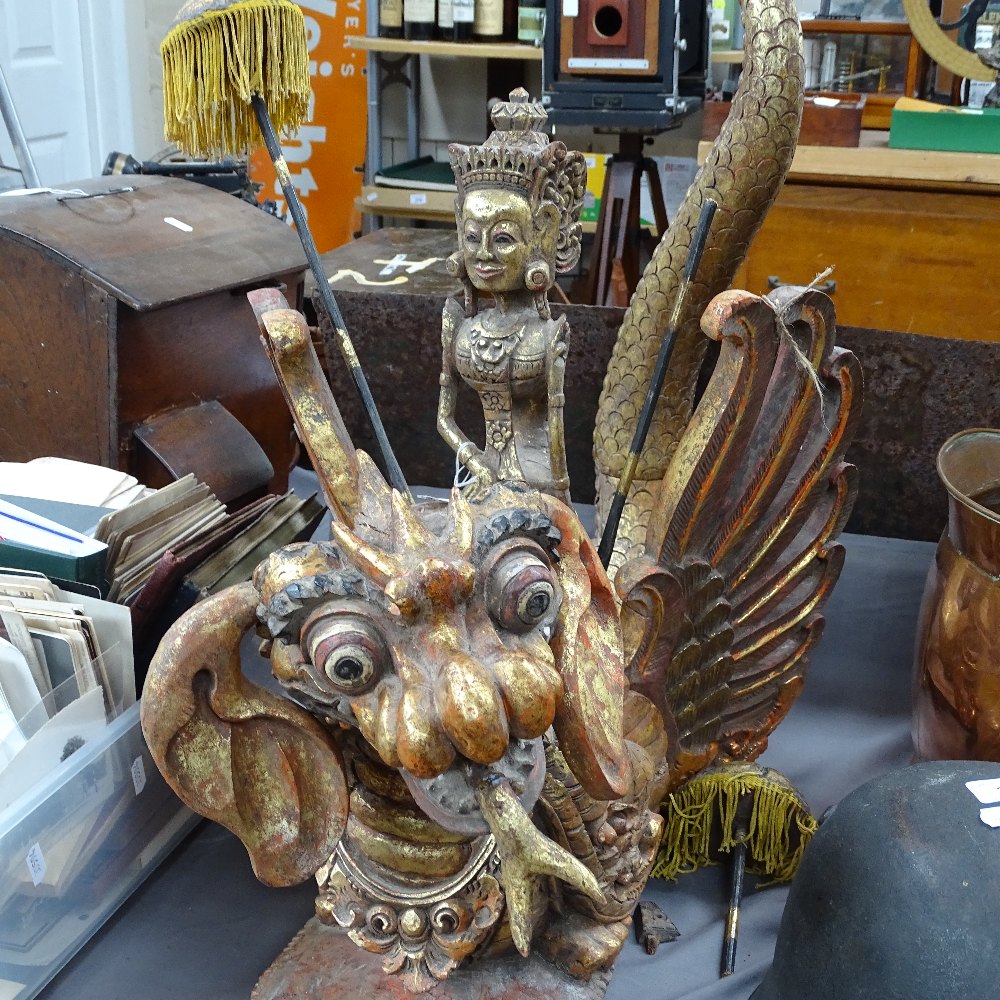 A large carved, painted and gilded wood Oriental dragon, surmounted by a figure with parasols,