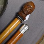 A silver-topped walking cane, and another with carved wood head knop