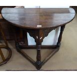 An oak console table in 17th century style, of demilune from, on triangular carved base, W92cm