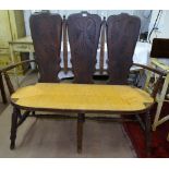 A 1920s French provincial settee, with 3 carved panelled back, rush-seated seat, on turned legs,