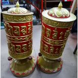 A pair of large ornate Tibetan relief embossed painted and gilded metal prayer wheels, height