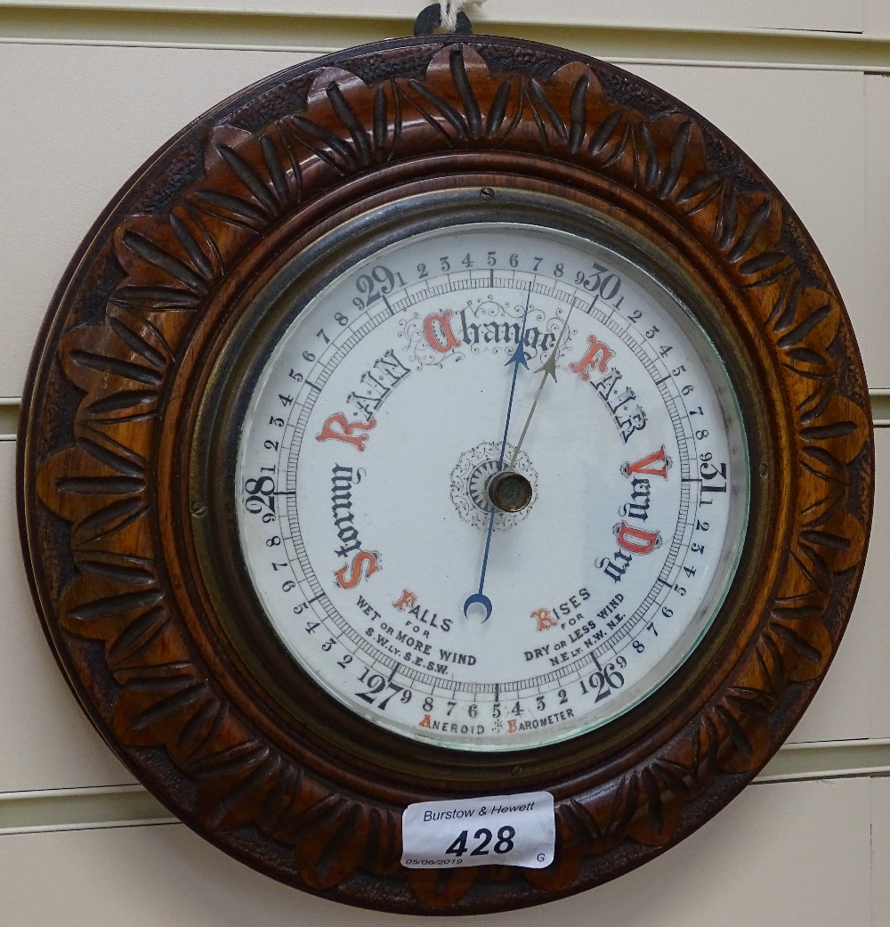 An aneroid barometer set in carved mahogany frame, diameter 8.5"