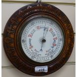 An aneroid barometer set in carved mahogany frame, diameter 8.5"