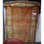 A red ground Afghan rug with symmetrical pattern, 220cm x 115cm