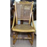 An Edwardian stained beech and cane-panelled rocking chair