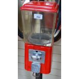 A Vintage red plastic bubblegum dispensing machine, on cast-iron stand, height 54.5"