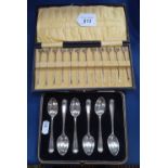 A cased set of 6 silver teaspoons, and a cased set of 12 silver cocktail sticks surmounted by gilded